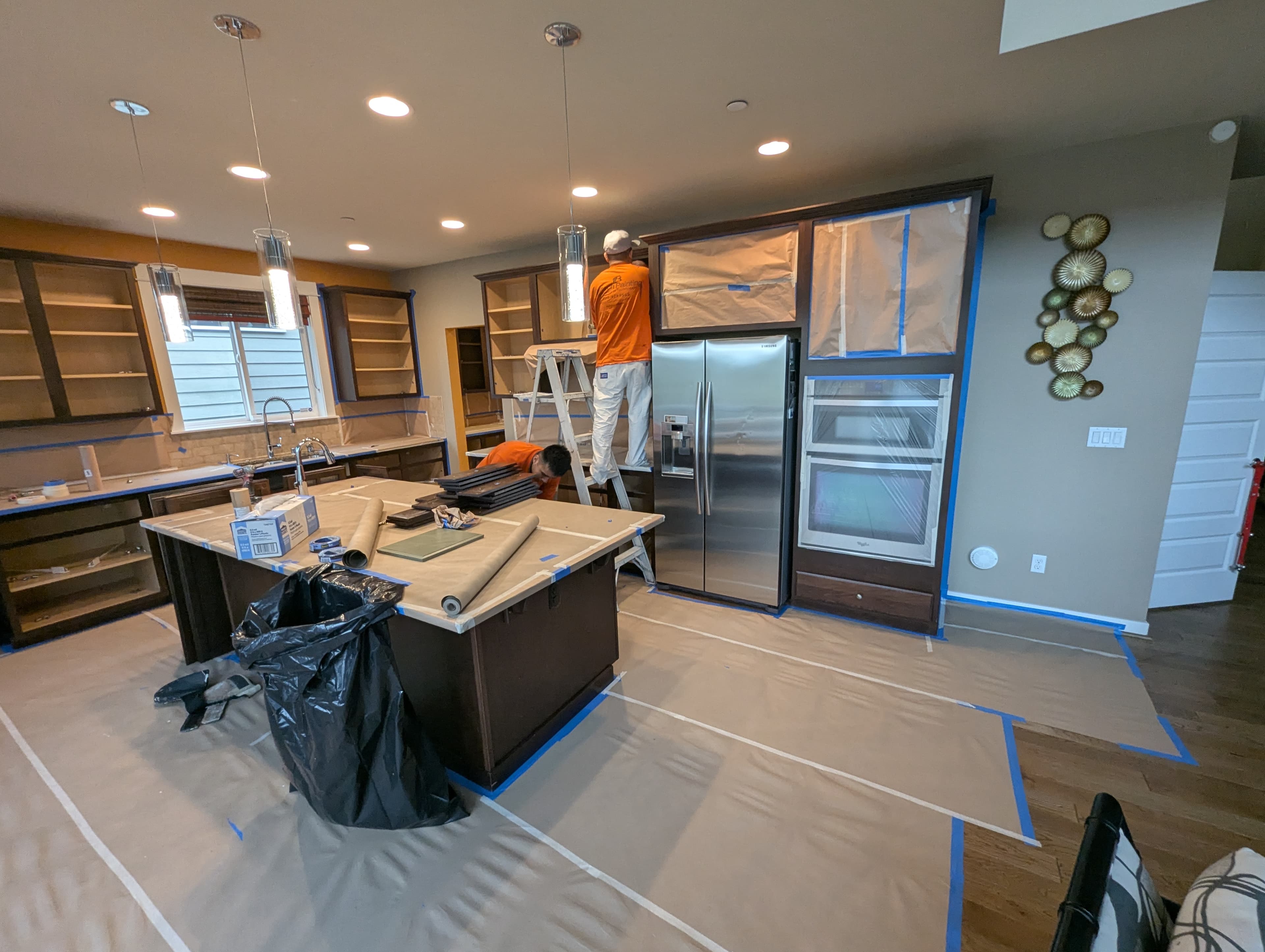 Alltech Painting team masking and preparing kitchen cabinets for a professional finish in Bellevue